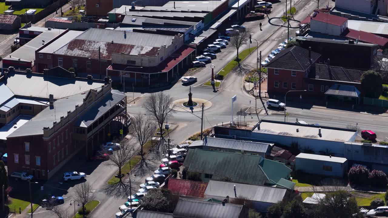 Drone ascends above rural Dorrigo town, revealing streets, buildings, and parked cars in daylight