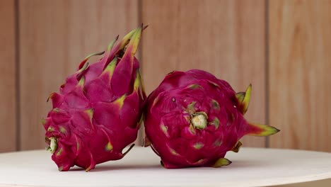 dragon fruits rotating on a wooden surface