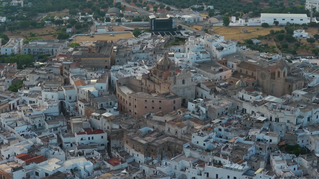 Historic centre of Ostuni, the White City, Cathedral and buildings, Puglia, Italy. Aerial backward tilt-up reveal
