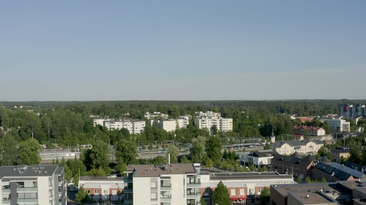 Hurtigt stigende luftfoto af en lille flod og togstation i en finsk by nær Helsinki.