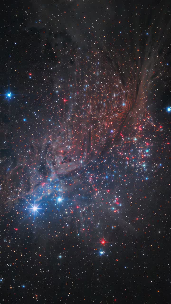 Vertical video: Panning telescope upward, revealing nebula filaments and blue cluster lower-left