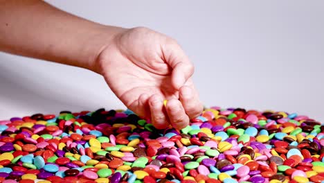 hand sorting colorful candies on a surface