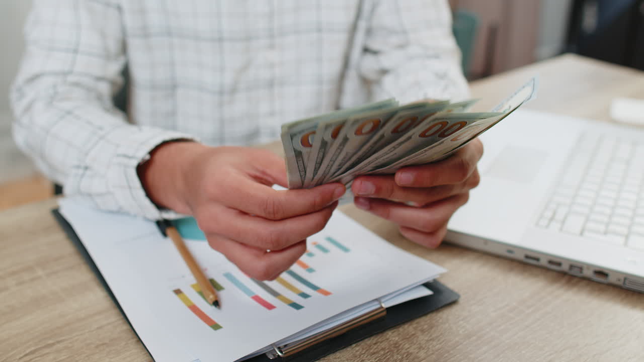 Prossimo piano mani di un uomo d'affari che contano denaro in contanti dollari che controllano lo stipendio godere della ricchezza profitto