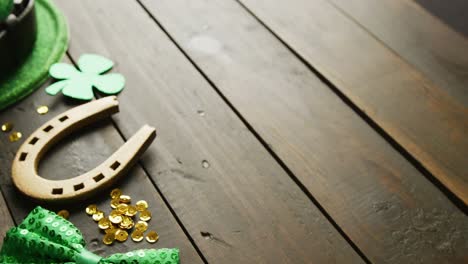 Video-of-st-patrick's-green-hat,-shamrock-and-horseshoe-with-copy-space-on-wooden-background