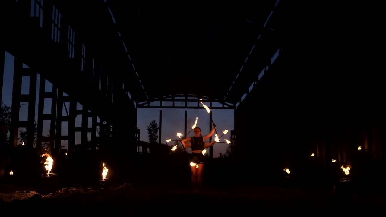 un grupo de artistas profesionales con fuego muestran el espectáculo haciendo malabarismos y bailando con fuego en cámara lenta.