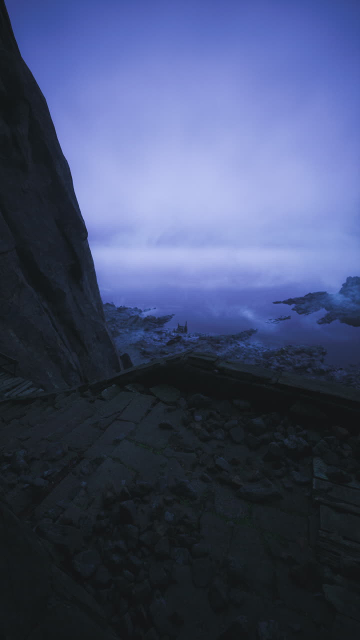 Mysterious twilight by the rocky shore with calm water and enchanting sky