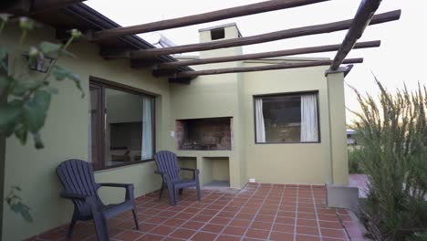 charming outdoor patio features a brick grill, wooden pergola, and comfortable seating, creating a perfect space for relaxation and entertainment in a modern home