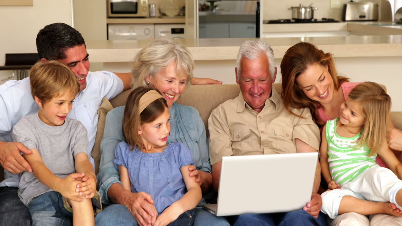 Extended family using laptop together on couch