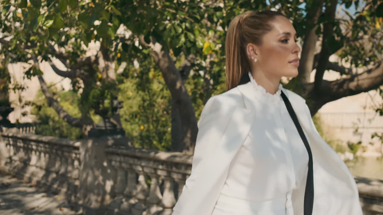 은 공원을 걸어다니는 세련된 젊은 여성.