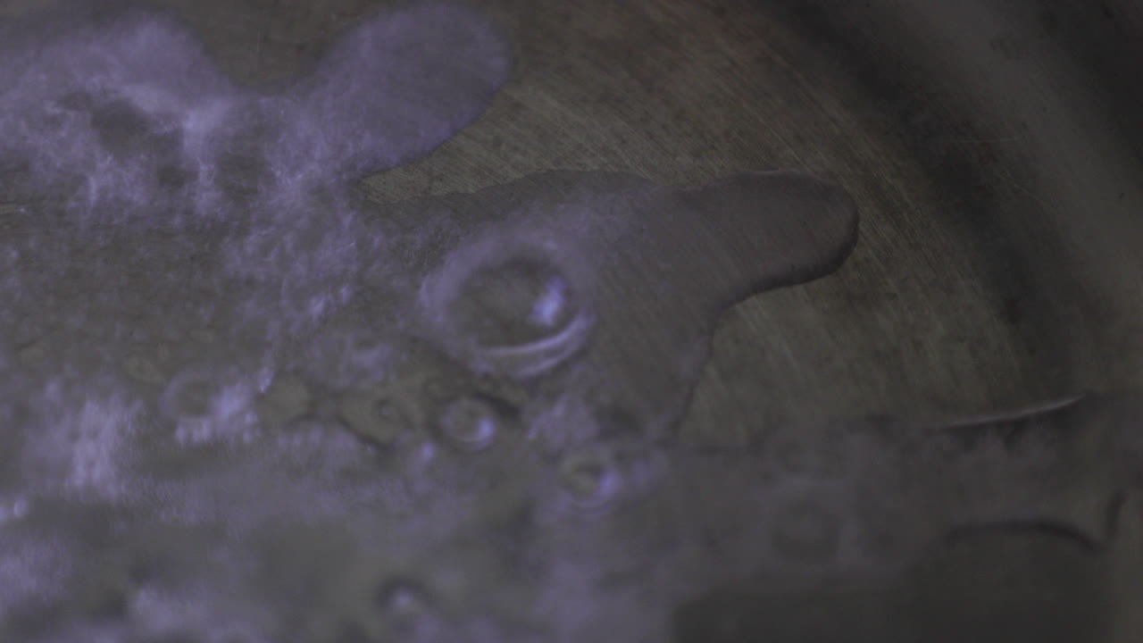 perspectiva extremadamente cercana que captura el estallido de las burbujas de agua caliente en la sísmica sartén caliente