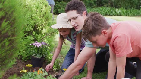 happy caucasian family working in garden on sunny day