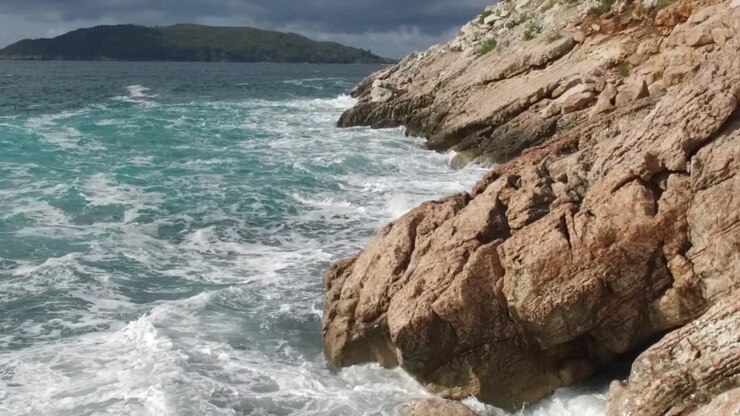 Le onde costiere si scontrano con le rocce