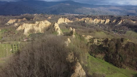 aerial flying drone shot over prehistoric age canyons forest le balze natural reserve near reggello. tuscany, chianti area. italy. winter season, partially sunny sunset.