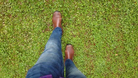 man in shoe walking on green surface