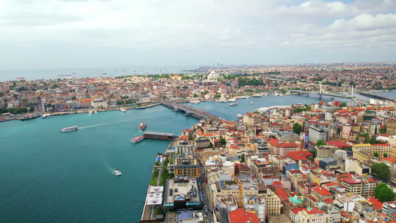 Aerial drone view of Istanbul, Turkey. Multiple residential buildings, mosques, Galata and Metro bridges over the Golden Horn waterway with multiple floating ships