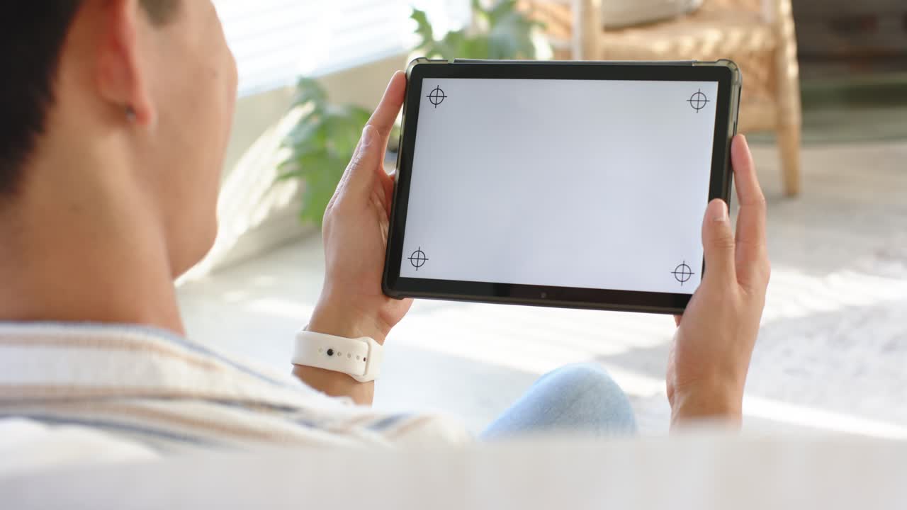 Ein Mann greift nach vorne und nimmt ein Tablet zur Bildschirmkalibrierung, wobei er Griff und Neigung anpasst