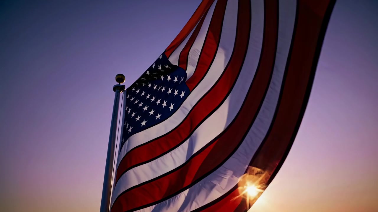 Bandiera americana che sventola contro un cielo al tramonto