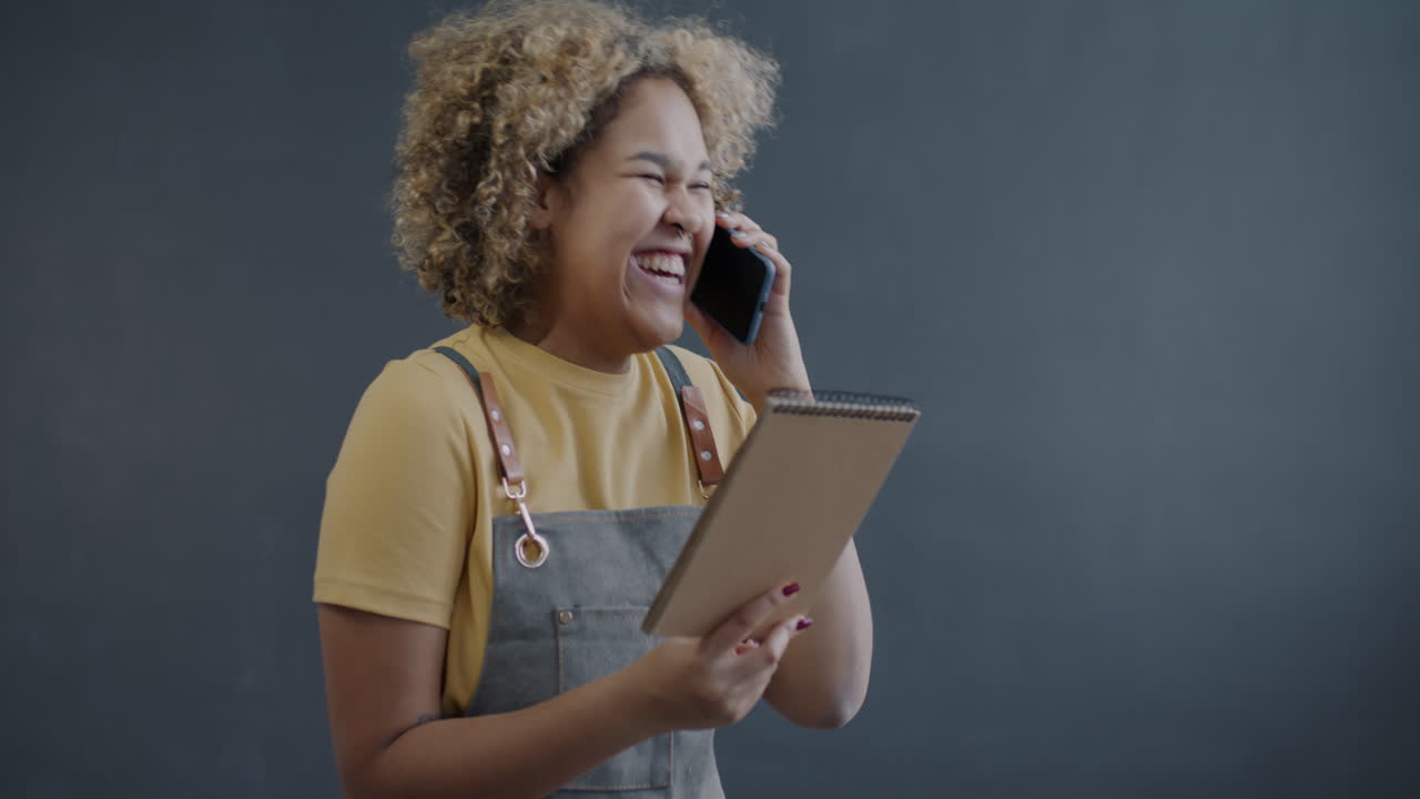 Woman Talking on Phone and Taking Notes