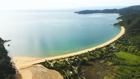 Antena-Sobre-La-Playa-De-Totaranui-Y-El-Camping-Ubicado-En-El-Parque-Nacional-Abel-Tasman,-Isla-Del-Sur,-Nueva-Zelanda