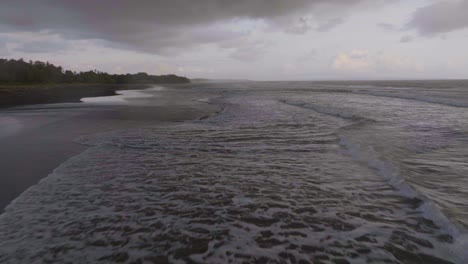 Beautiful-Black-Sand-Beach-in-Popular-Tourist-Travel-Destination-of-Bali,-Aerial