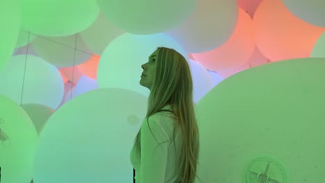 a captivating moment as a girl strolls through an immersive installation of glowing lightning balls at teamlab planets, tokyo.