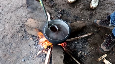 cerca de gente africana local hirviendo café molido en una hoguera antes de beberlo