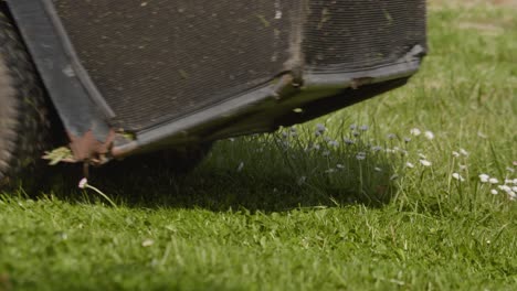 old rusty lawn tractor moving on green spring grass