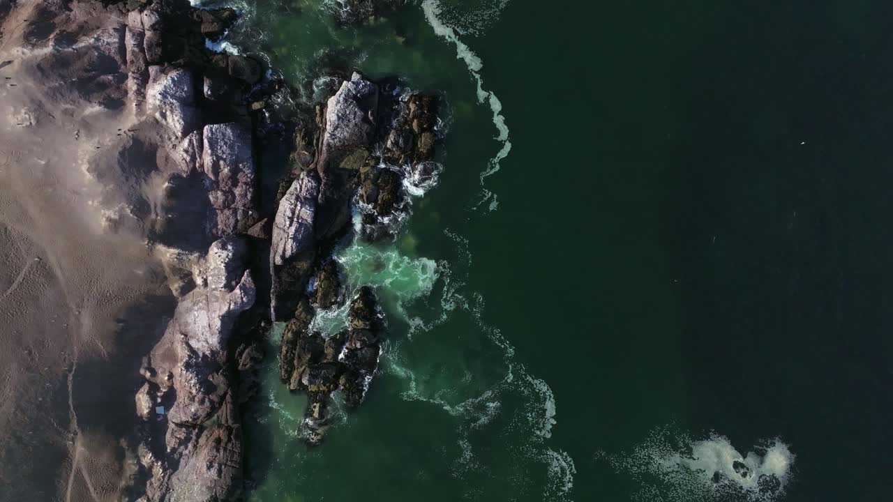 Ripresa dall'alto al rallentatore di onde che si infrangono contro le rocce a Iquique, Cile