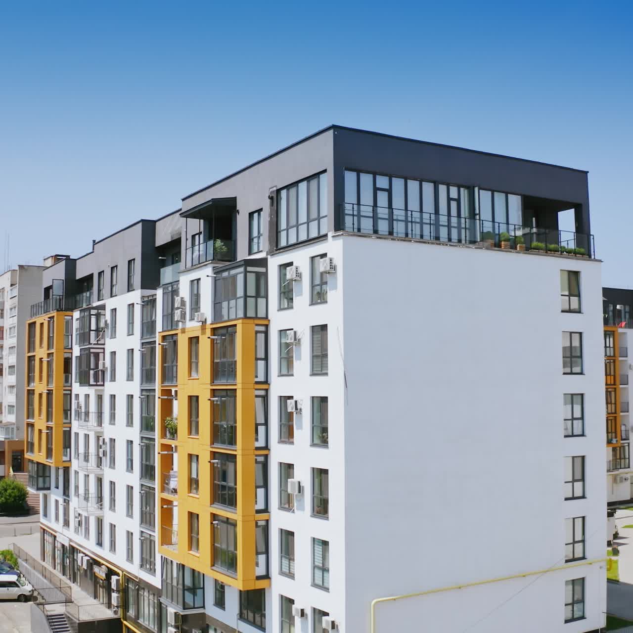 Urban background in sunny daytime. Exterior of a new apartment building. Modern design of high-rise building with large windows and balconies