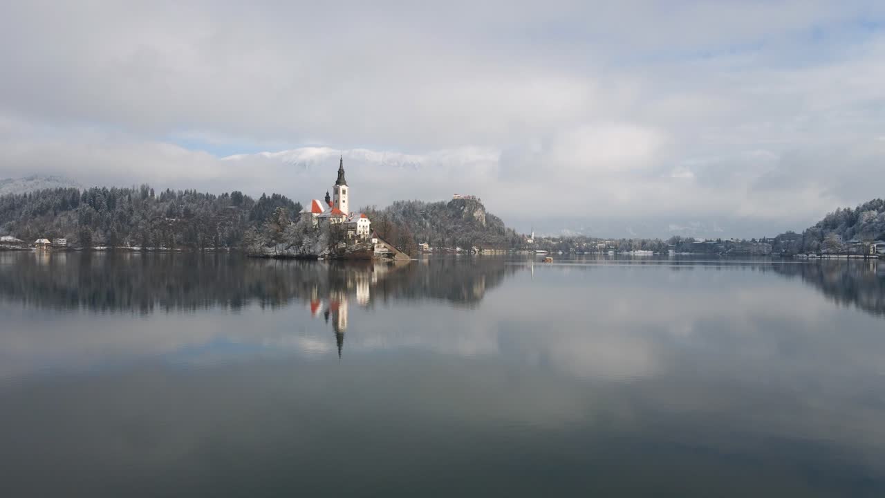 Ripresa aerea a bassa quota sopra il lago di Bled verso l'isola della chiesa di giorno.