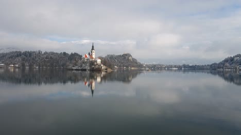 Low-flying-aerial-over-lake-bled-towards-church-island-islet-day
