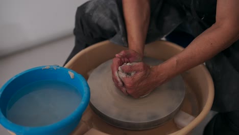 close-up of hands shaping clay on a potter's wheel