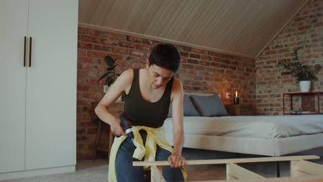 mujer montando un marco de cama de madera