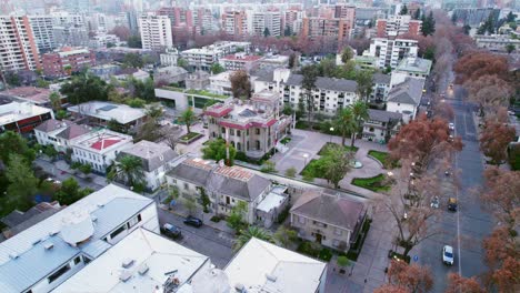 Flyover-establishing-over-the-Falabella-Palace-Municipality-of-Providencia-Santiago-Chile-orange-trees-autumn-trees