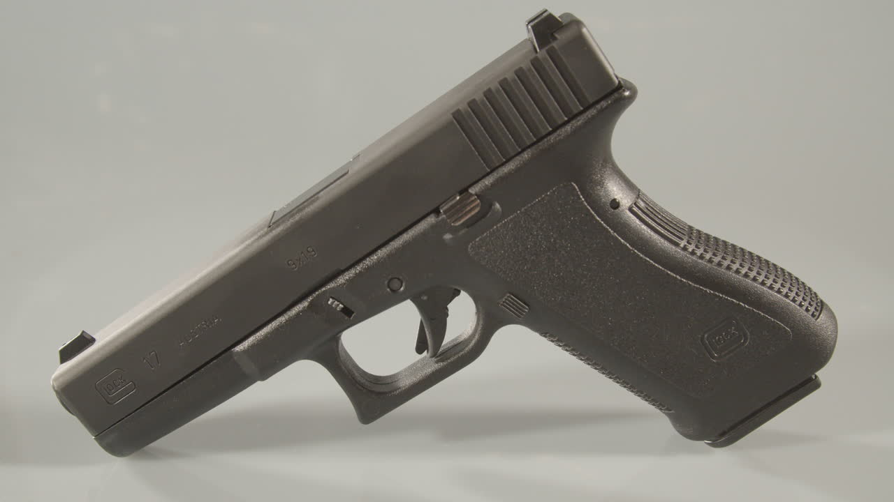 Panning over 9mm handgun against a white background