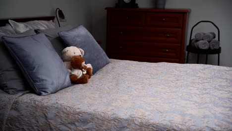 cozy furnished bedchamber with a grey double bed and two teddy bears