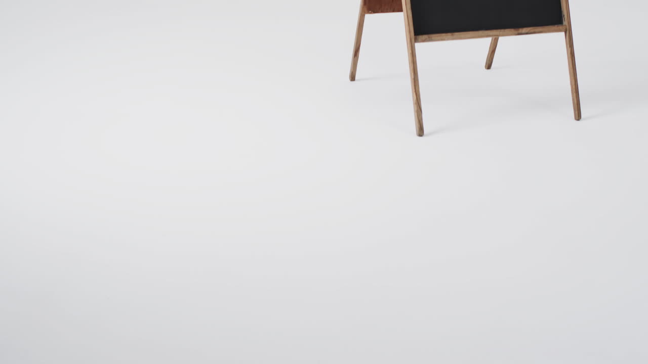 Video of blackboard sign on wooden stand with copy space on white background