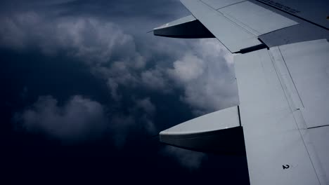 el ala del avión por encima de las nubes oscuras