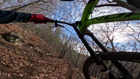 mtb rider pov carrying bike uphill in fall trail