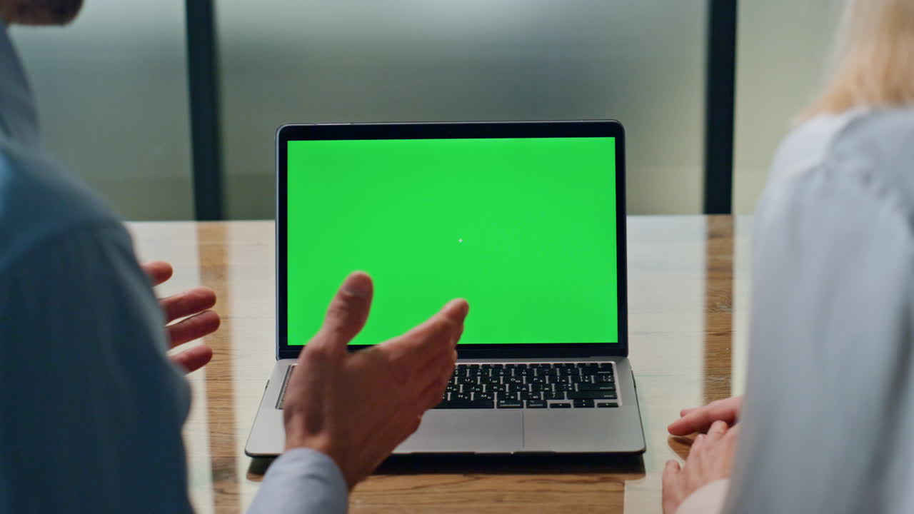 una pareja de empresarios hablando en video en una maqueta de portátil.