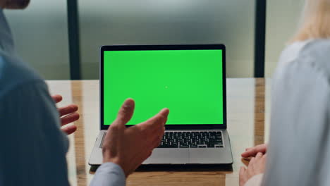 una pareja de empresarios hablando en video en una maqueta de portátil.