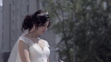 Zeitlupenbraut-Mit-Tiara-Im-Haar-Blickt-Auf-Blumenstrauß