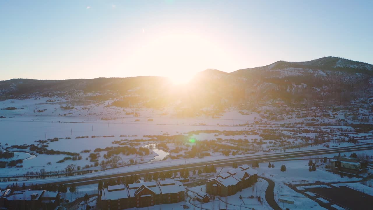 Beautiful bright sunset behind the mountains by a town in Colorado - Aerial Drone