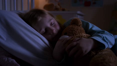 child sleeping with teddy bear