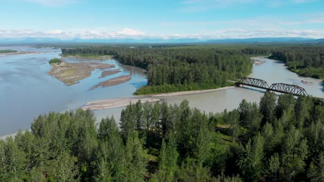 4k drone video of alaska railroad train trestle with mt