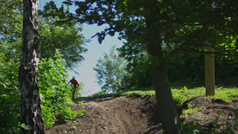 Slow-motion-male-mountain-bike-rider-cyclist-biking-on-a-trail-through-the-woods