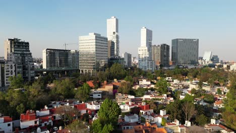 drone-flight-at-south-of-mexico-city,-it-seems-clean-and-there-are-some-buildings-with-a-lot-of-trees-and-a-big-second-level-for-cars-driving-on-the-way