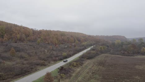 Approaching-drone-shot-and-following-a-moving-car-that-is-cruising-on-a-road-above-the-Balkan-Mountain-range-in-Dimovo-Municipality-in-Bulgaria