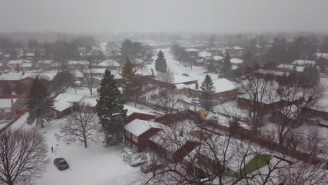 aerial rise over snow covered houses in a residential neighborhood