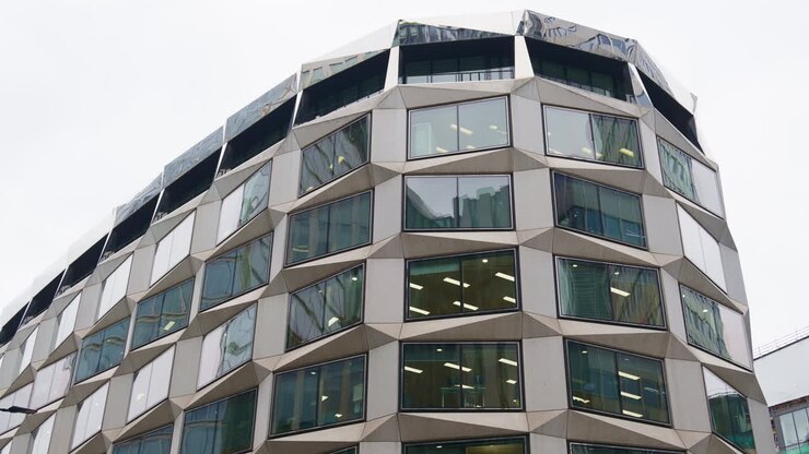 Close-up da fachada exclusiva de um prédio de escritórios com molduras de janela geométricas e angulares em Londres, Inglaterra, perto do centro financeiro